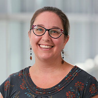 Sally has brown hair and wears black-framed glasses