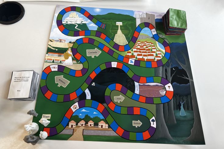A snake-like path across a board game is laid across a colorful background with Greek lettering