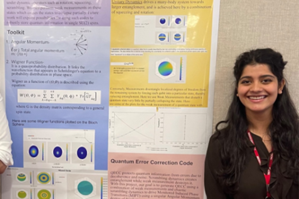 Srishti stands with her poster at a conference