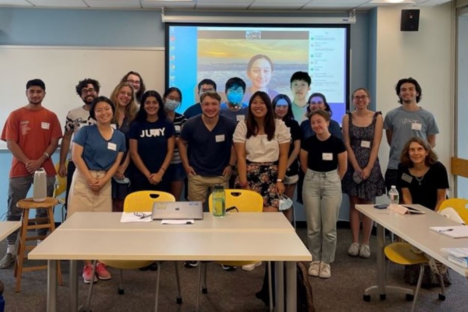 A group of students stand in front of a whiteboard