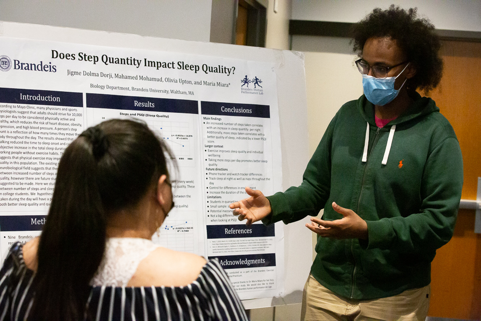 A student explains their poster to an attendee at the URCC symposium