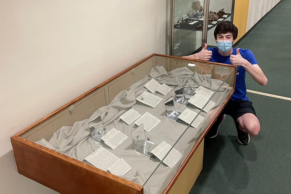 Joey Kornman gives a thumbs up to his newly completed library exhibit on Roman Coins.