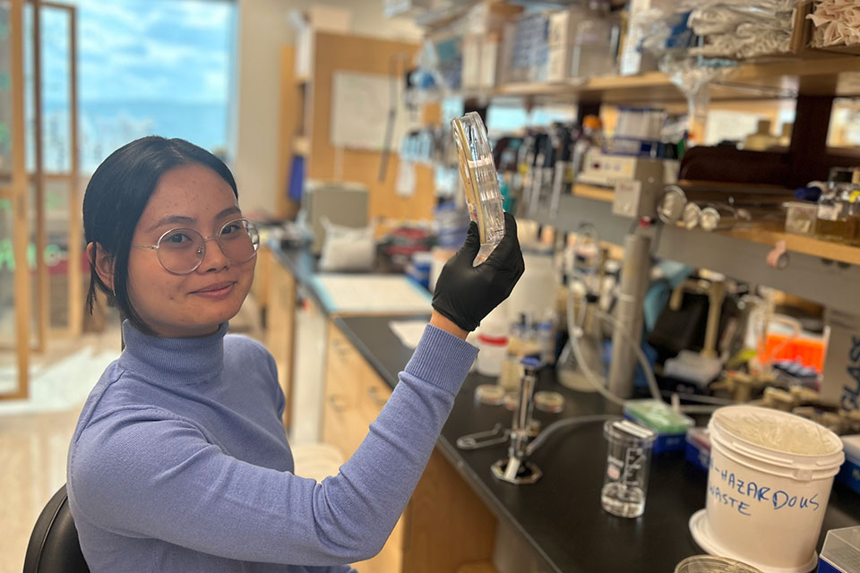 Uyen object in her hands and smiles at the camera