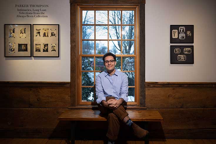 Parker Thompson '23 posing with his collection of photo images