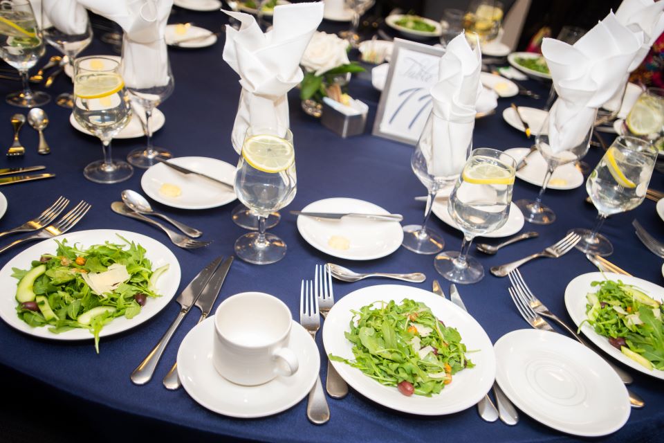 Dining table laid out with dinner plates and salad servings