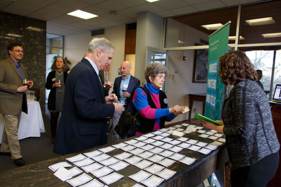 several people picking up name tags at a conference registration table