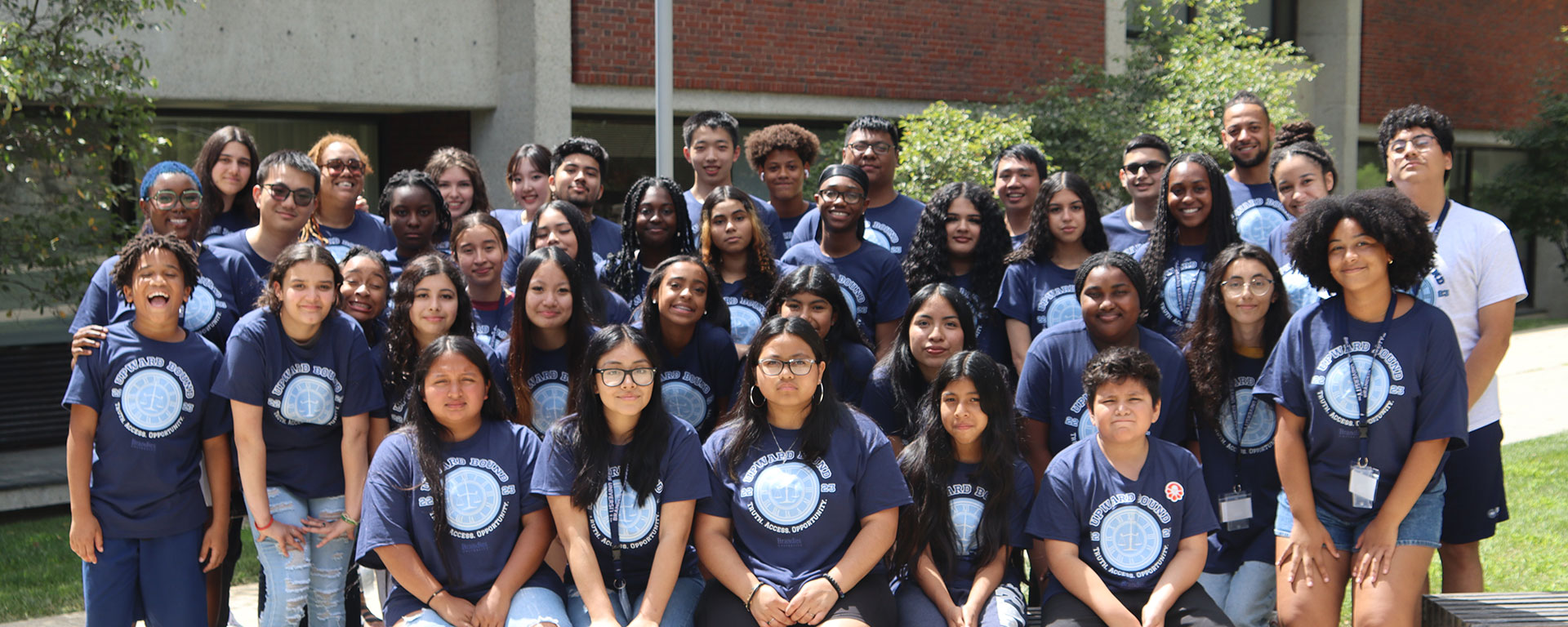 A group of students stand together and smile for a group photo.