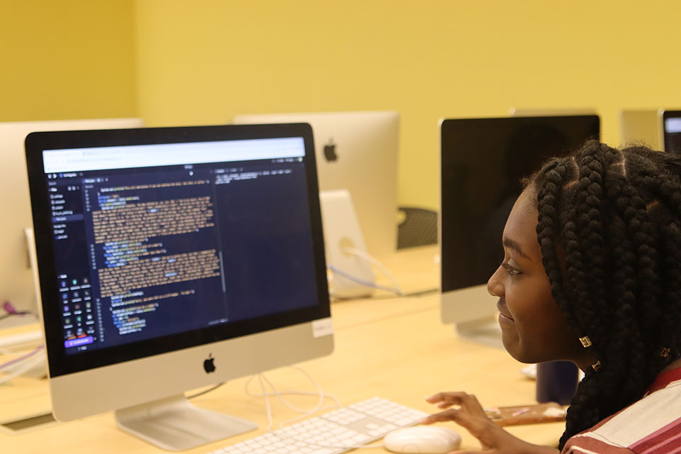 A student sits in front of a computer.