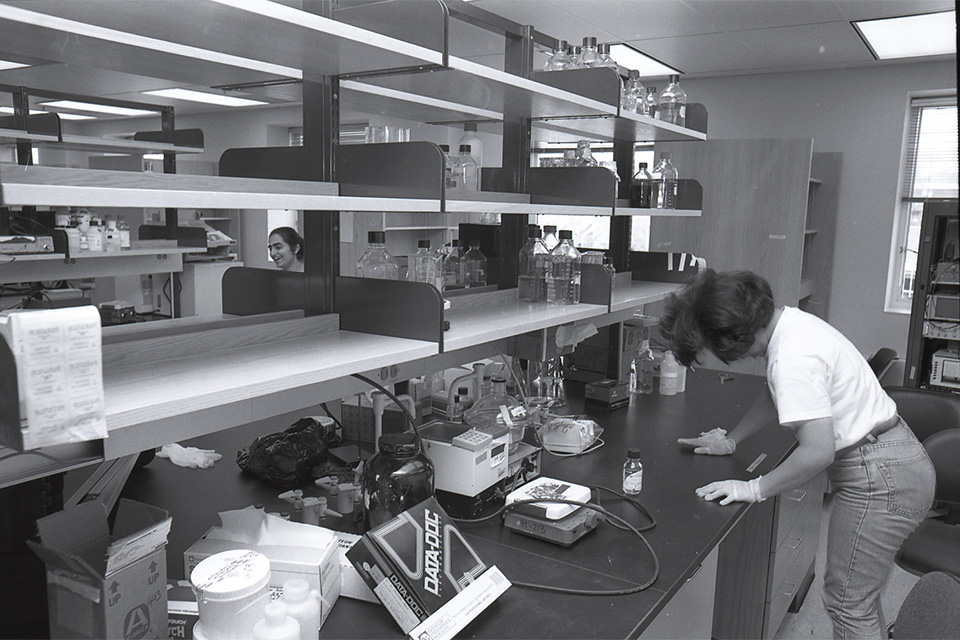 Person cleaning a tabletop in a new labspace in Volen.