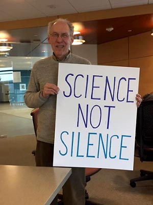 Man holding his poster that says: Science not Silence