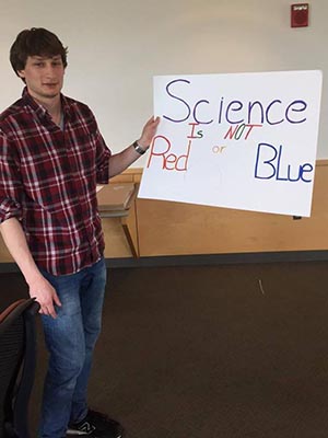 Student holding his poster which says: Science is not Red or Blue