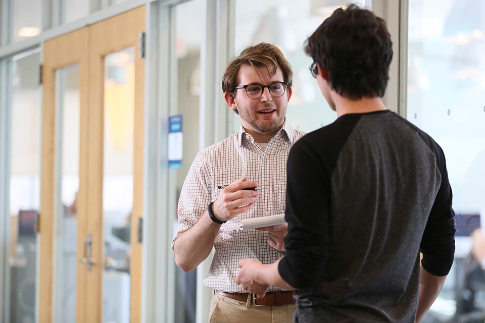 two people talking in a hallway