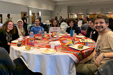 smiling students gathered around lunch table