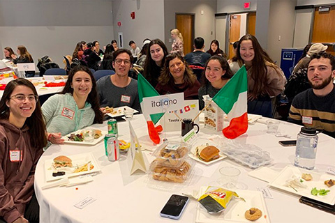 students seated at lunch table with italian flags