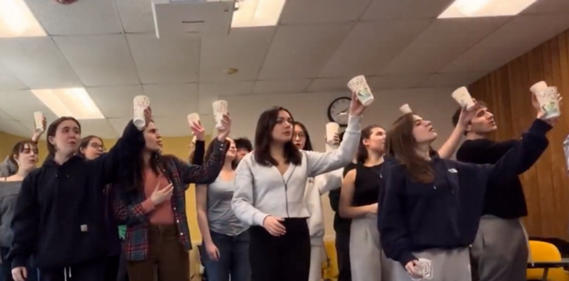 Many students lifting cups