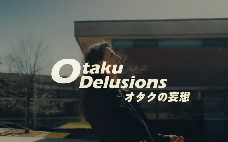 A student standing behind the words otaku delusions.