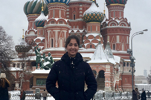 woman poses in front of russian buildings