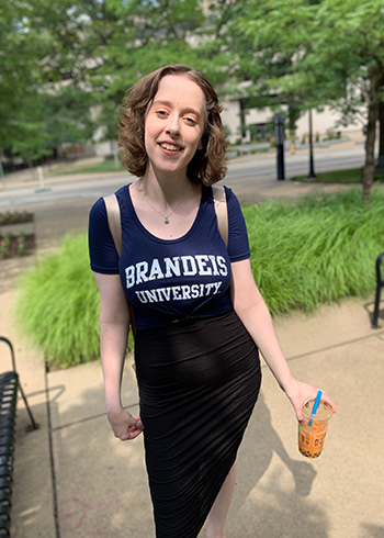 maddie herrup posing in brandeis shirt on campus