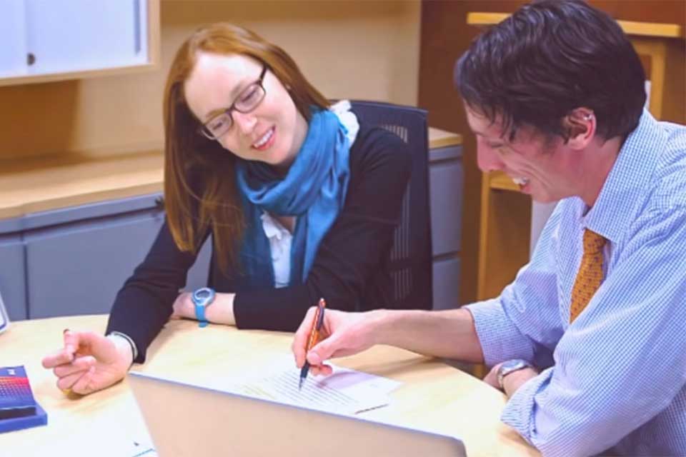 man and woman discussing work at table