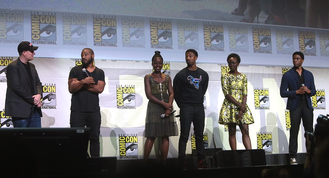 (L-R) Producer Kevin Feige, director Ryan Coogler, and actors Lupita Nyong'o, Michael B. Jordan, Danai Gurira, and Chadwick Boseman promoting Black Panther at the 2016 San Diego Comic-Con. Photo: Gage Skidmore - https://www.flickr.com/photos/gageskidmore/28018675963/, CC BY-SA 2.0, https://commons.wikimedia.org/w/index.php?curid=50394163