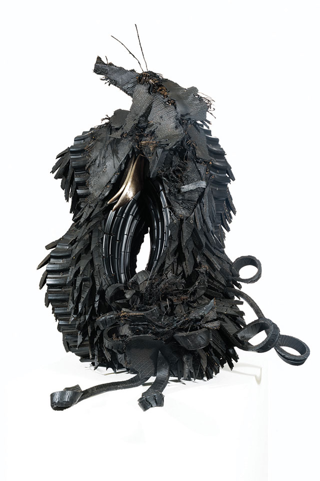 Chakaia Booker, "The Nest," 2003, Rubber tires, wood and steel, 40.5" x 30.5" x 22". This sculpture made from recycled materials is oblong and evokes natural imagery. Although it is titled "the Nest" it has the appearance of a creature with 2 feet and a tail. 