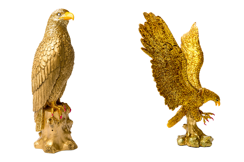 two painted golden eagle statues, covered with gold glitter. nails painted hot pink