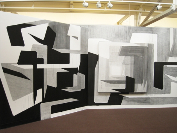 "Father Tongue," installation view of Milcah Bassel's exhibit. Photo shows a drawing that fills the entire dimensions of two walls.  The drawing is in shades of black, white and gray and are loosely related to letterforms of the Hebrew alphabet. There is one inset image of similar shapes on a raised panel overlapping the drawing on one of the walls.