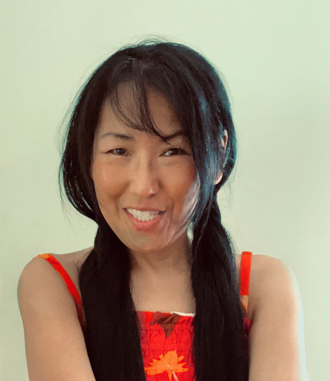 A color photograph of artist Jai Hart smiling. 