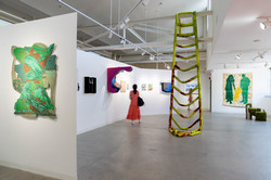 women standing in Kniznick Gallery amidst art