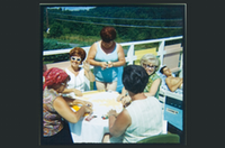group of women sitting around white table on boat playing cards