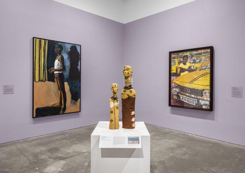 picture of room with purple walls holding two paintings and two statues