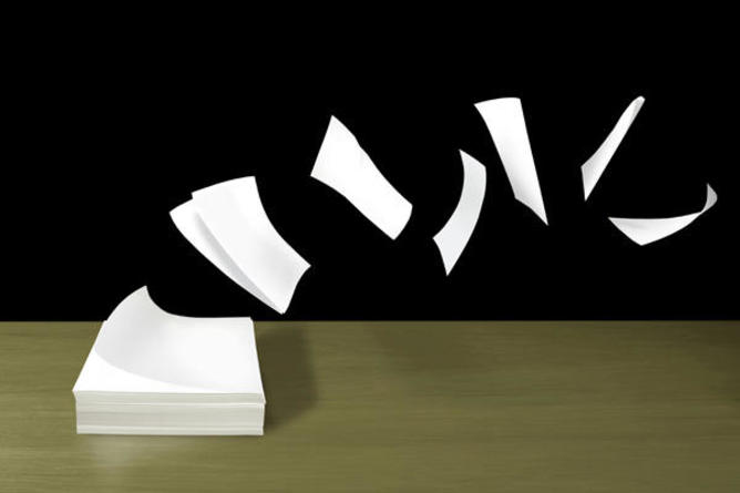 pile of paper with top sheets flying off