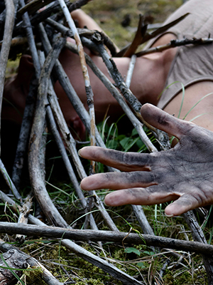 close up of woman's head, her head obscured by a stick structure
