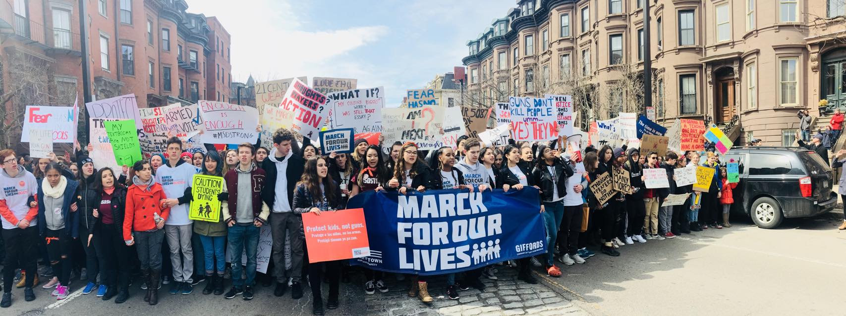 A group of teens with signs supporting gun control