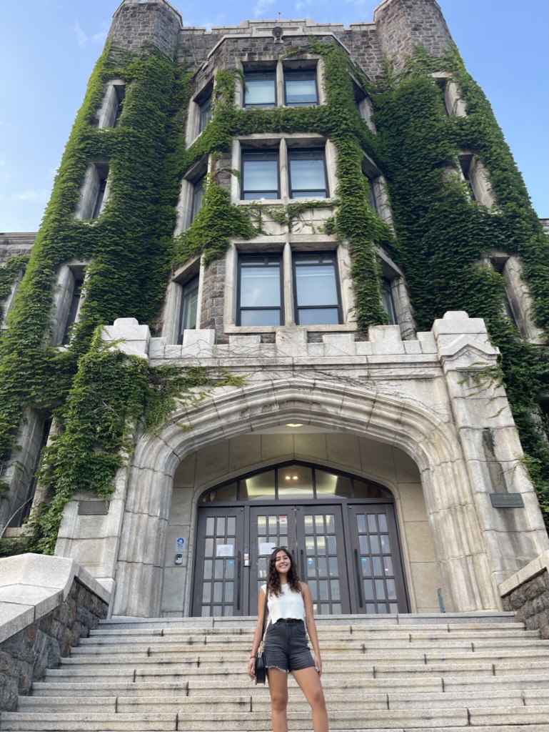 Lorena standing in front of an ivy-covered classroom building on the Yonsei campus.