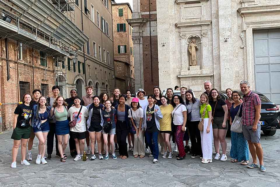 A group of students standing on a medieval cobblestone street