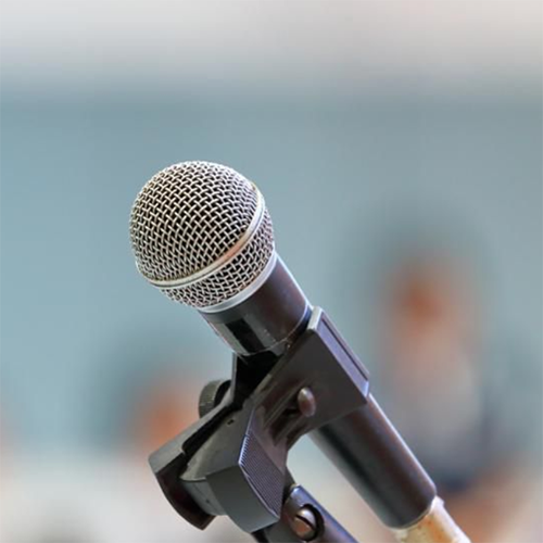 Microphone for speaker's speech in the seminar room with audience in the background
