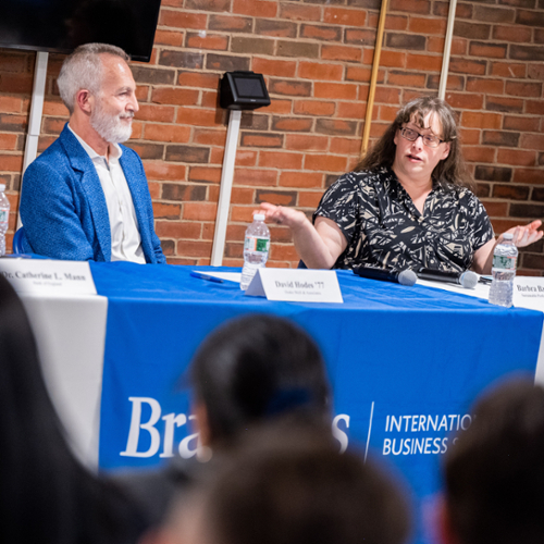 One panelist gestures as she speaks while a second listens beside her.