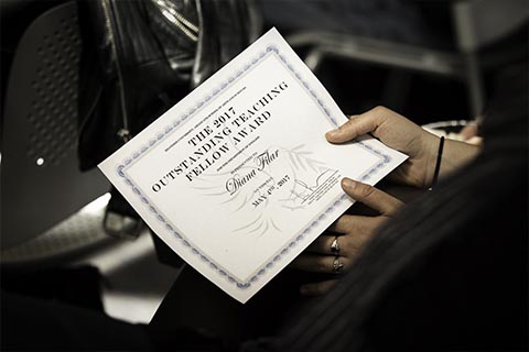 A student holds her teaching award certificate.