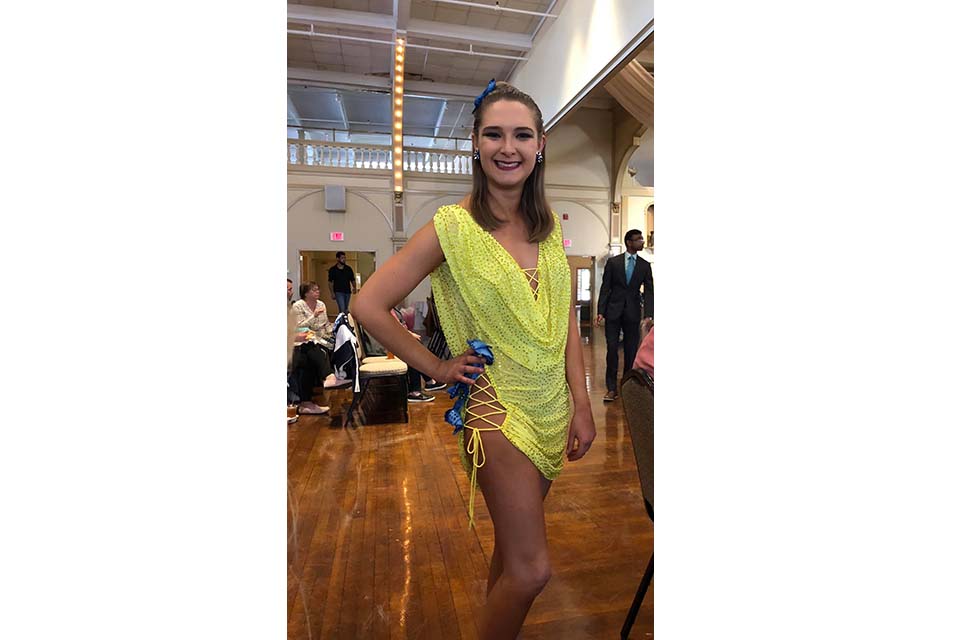 Emily Calobrisi poses in a colorful ballroom dance costume.