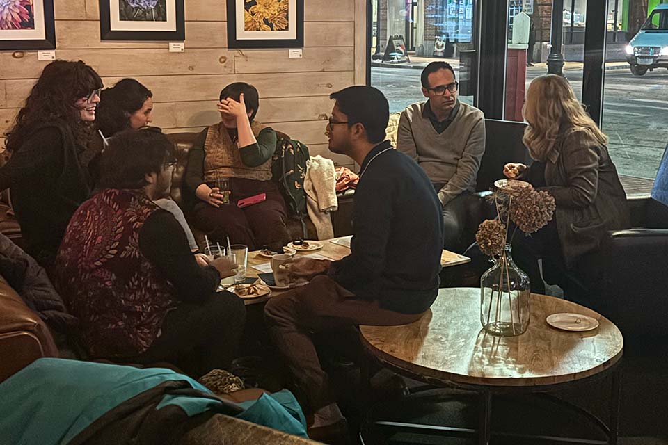 A small group of students sits on chairs and couches at Brewer's Tap and Table, having conversations.