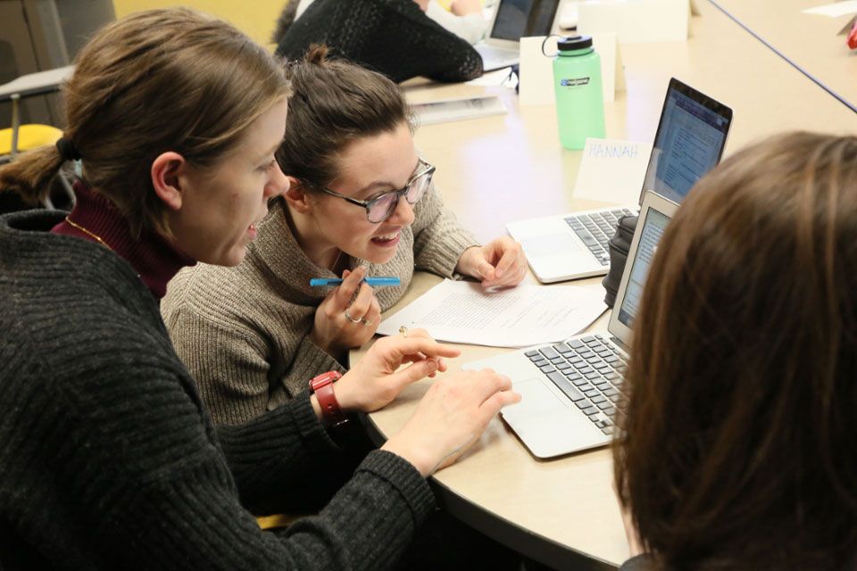 Two students look at laptop