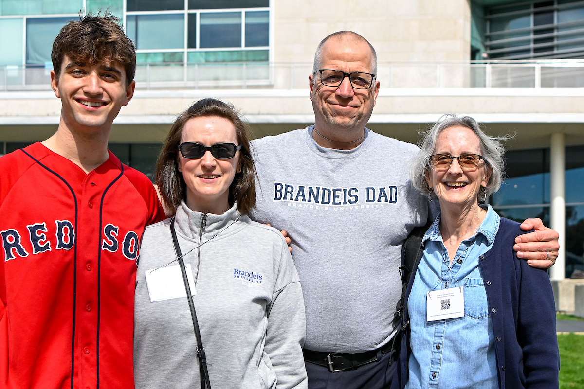 Parents hug their student while posing for a photo during Family Weekend 2022