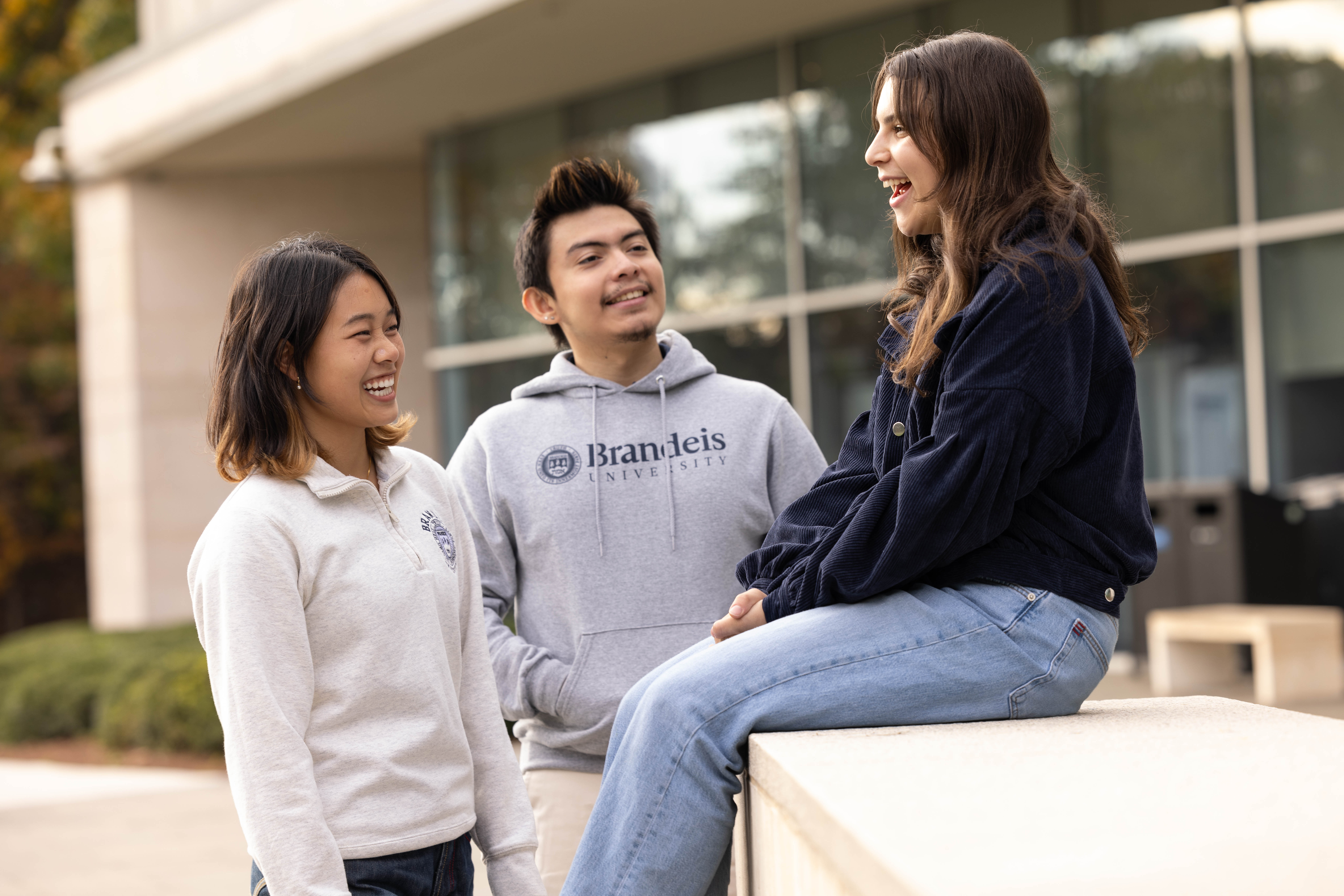 From right, Elienne Grossman, ’26, Lola Hamilton, ’26, Mikey Terrenzi, ’25, hang out beside the Student and Knowledge sculpture outside of the Brandeis University libraries on May, 9 2023.Photo/Gaelen Morse