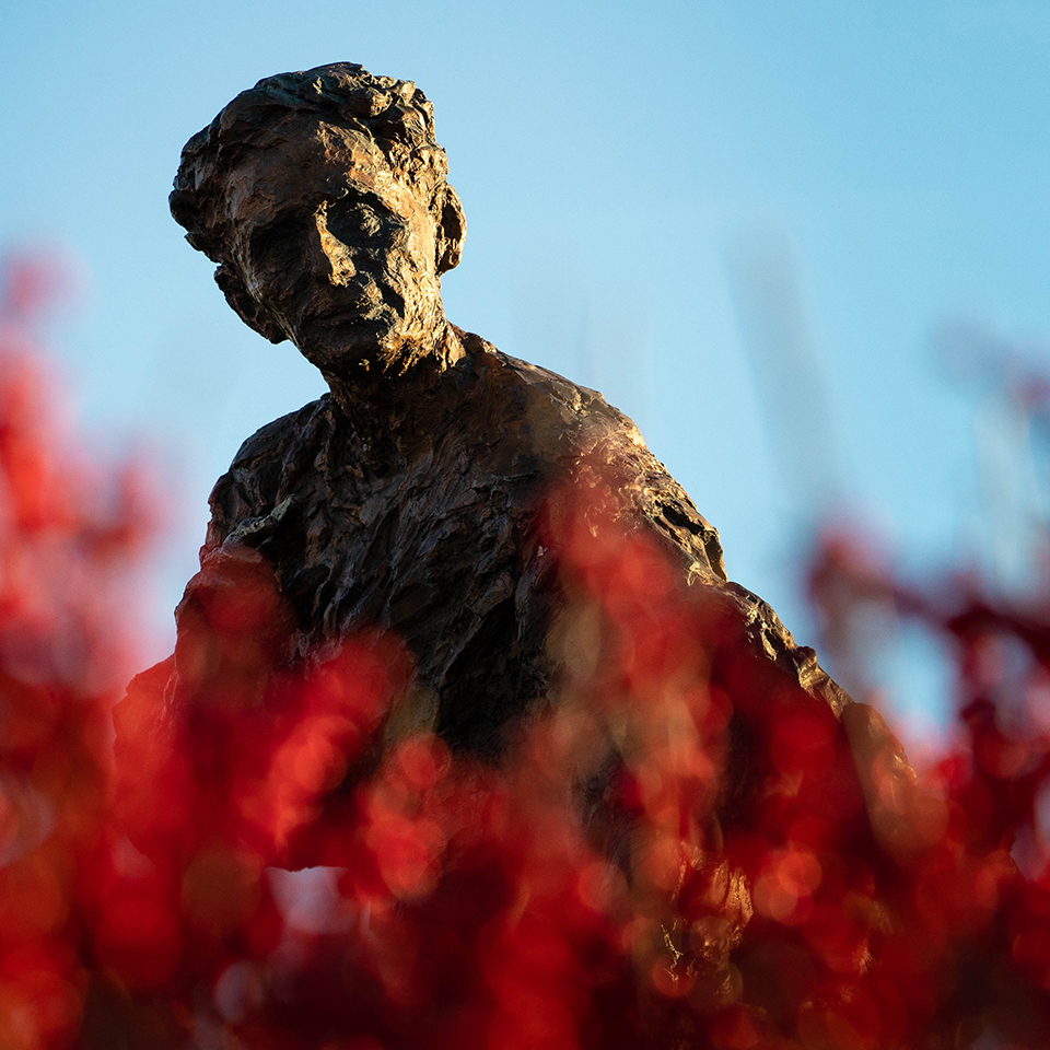 Statue of Louis D. Brandeis surrounded by flowers.