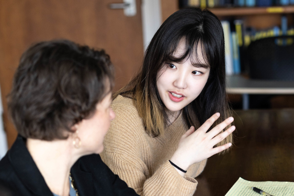 Graduate students talk to each other at the Heller School at Brandeis University on April 18, 2023. Photo/Dan Holmes