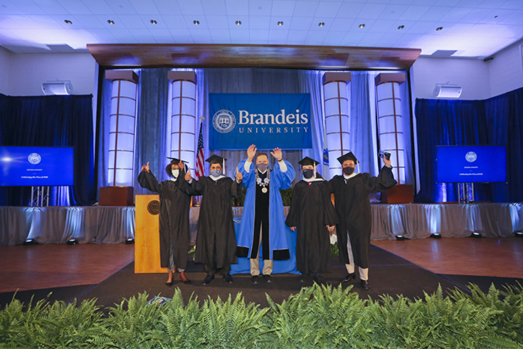 President of Brandeis, Ronald D. Liebowitz, poses with students during the 2021 Walk the Stage commencement event. 