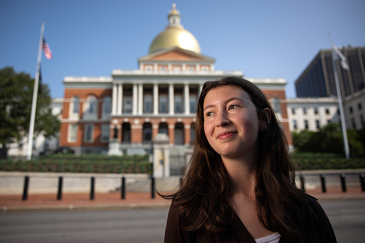 A girl stands in front of a building.