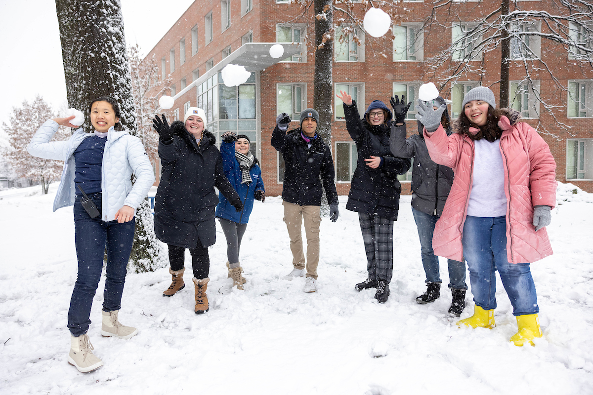 Seven students throw snowballs.