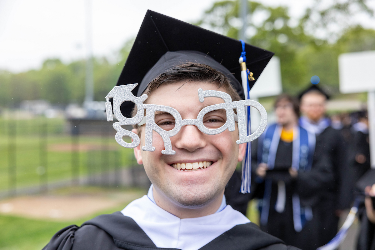 Brandeis University student wears "graduate" glasses.